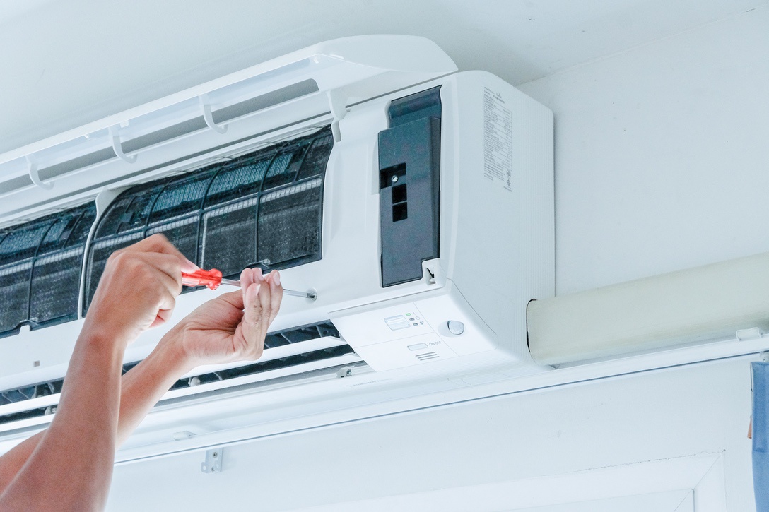 Homeowner performing basic maintenance on ductless mini split AC