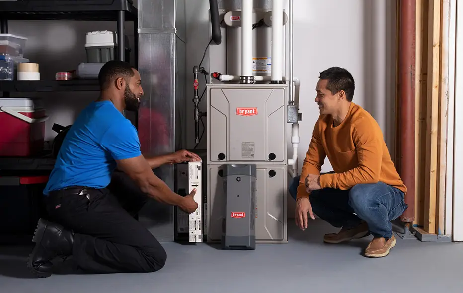 Tech and customer looking at furnace